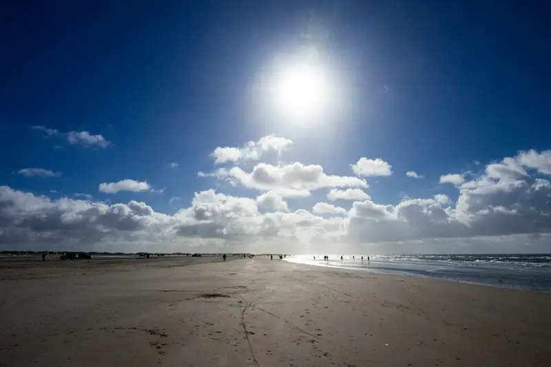 Sol över sandstrand och vågor vid Rømø
