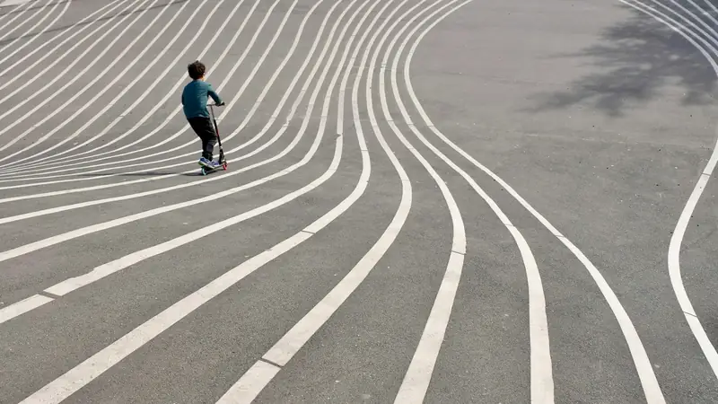 Barn på sparkcykel på Superkilens mönstrade mark