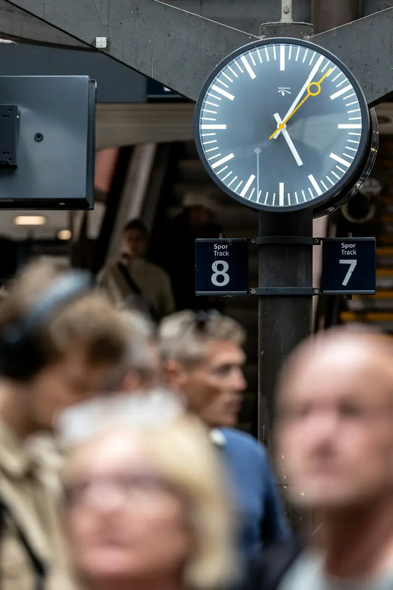 Stationshall med klocka och resenärer i Köpenhamn