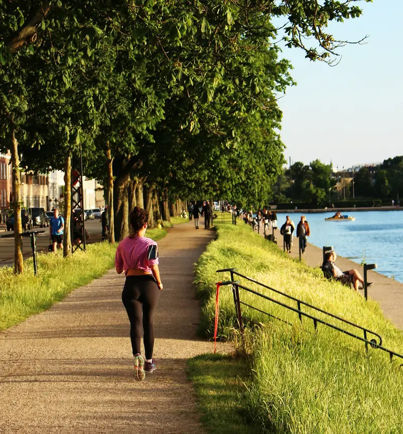 Person som joggar vid vatten i en park