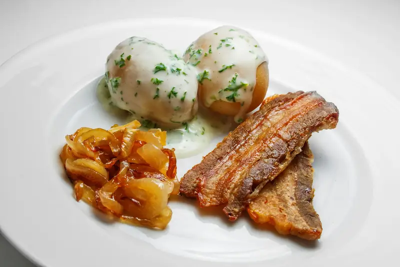 Dansk stegt flæsk med potatis och persiljesås på en tallrik